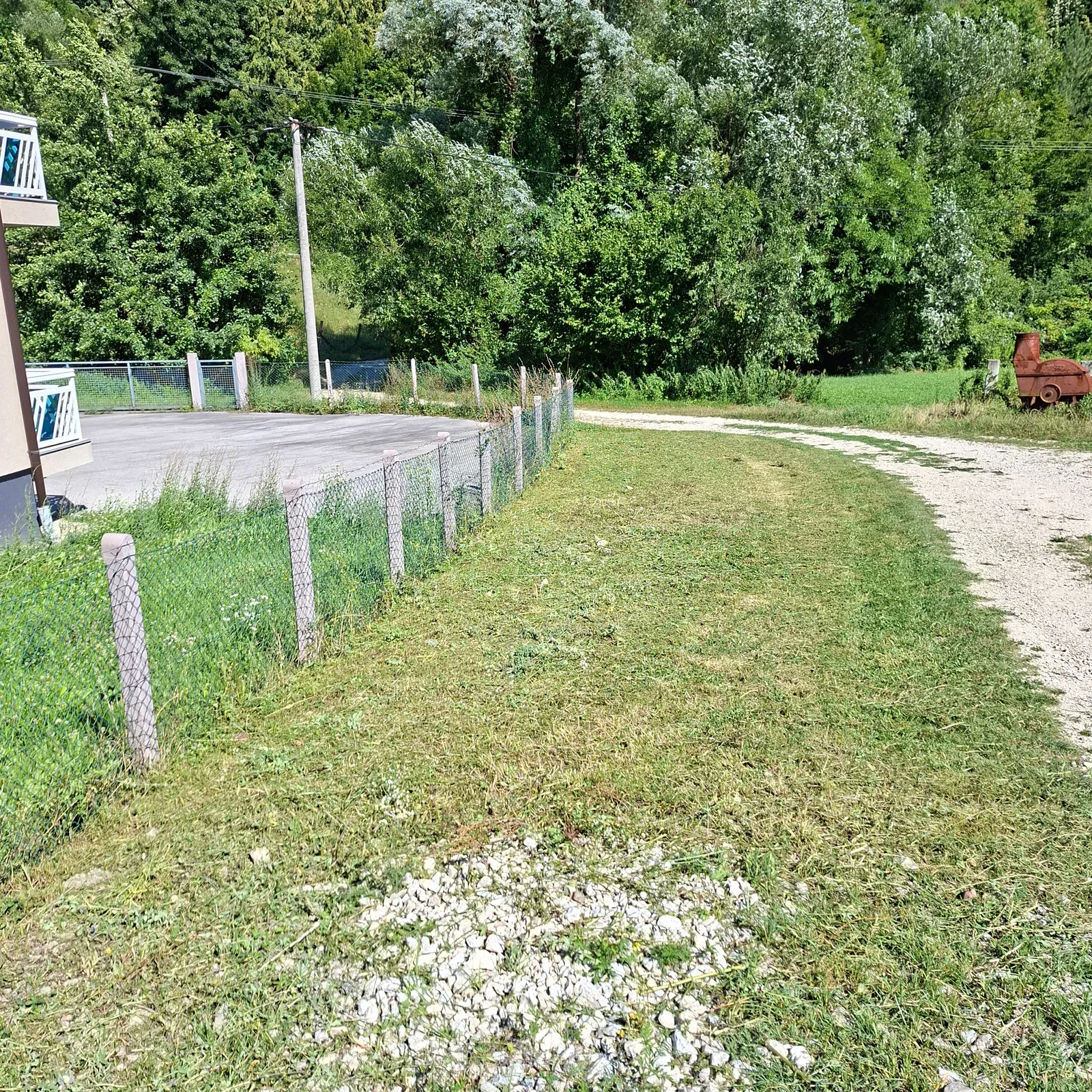 Uređen vrtni prilaz i pokošena zelena površina nakon rada.